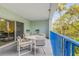 Cozy covered patio with seating, a table, and views of the tropical landscape at 5300 S Atlantic Ave # 9-206, New Smyrna Beach, FL 32169
