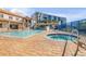 Community pool with hot tub and lounge area surrounded by palm trees and lush landscaping in resort community at 5300 S Atlantic Ave # 9-206, New Smyrna Beach, FL 32169
