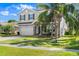 Charming two-story home with a two-car garage, complemented by lush landscaping and mature palm trees at 5337 Royal Plantation Blvd, Port Orange, FL 32128