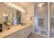 Large bathroom featuring double sinks, an expansive framed mirror, and a glass door shower at 5430 Dubois Ave, Port Orange, FL 32127
