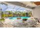 Inviting screened-in pool area with a spa, lush landscaping, and outdoor seating at 5430 Dubois Ave, Port Orange, FL 32127