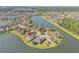 An aerial view showcases a home on a waterfront lot with a screened pool and lush landscaping at 610 Mura Ct, New Smyrna Beach, FL 32168