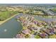Aerial shot highlighting a waterfront community with numerous homes with screened-in pools and lake views at 610 Mura Ct, New Smyrna Beach, FL 32168