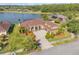 Aerial view of a well-maintained waterfront home with a screened-in pool and lush landscaping at 610 Mura Ct, New Smyrna Beach, FL 32168