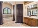 A view of the bathroom tub and vanity with decorative columns and window, offering a serene and elegant retreat at 610 Mura Ct, New Smyrna Beach, FL 32168
