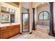 This bathroom has dual vanities, a standalone shower, columns and an arched window that adds architectural interest at 610 Mura Ct, New Smyrna Beach, FL 32168