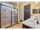 Bathroom with a frameless shower, dual sink vanity with matching dark wood cabinets, and tile flooring at 610 Mura Ct, New Smyrna Beach, FL 32168