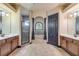 Luxurious bathroom featuring dual vanities, a shower, and a tub set under an arched window and decorative columns at 610 Mura Ct, New Smyrna Beach, FL 32168
