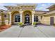 Inviting home entrance with arched windows and decorative landscaping at 610 Mura Ct, New Smyrna Beach, FL 32168