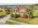 An attractive home with lush landscaping, a large driveway, and a well-manicured lawn near a lake at 610 Mura Ct, New Smyrna Beach, FL 32168