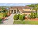 Beautiful front view of this tan single-Gathering home with a brown roof and manicured lawn at 610 Mura Ct, New Smyrna Beach, FL 32168