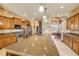 A kitchen featuring wood cabinets, stainless appliances and a large granite countertop island at 610 Mura Ct, New Smyrna Beach, FL 32168