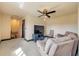 Relaxing living room with comfortable seating, a ceiling fan, a television, and neutral carpet at 610 Mura Ct, New Smyrna Beach, FL 32168