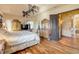 Well-lit Primary bedroom features wooden floors, closet, and dresser with mirror at 610 Mura Ct, New Smyrna Beach, FL 32168