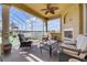 Relaxing covered patio with comfortable seating, fireplace, ceiling fan, and stunning lake views at 610 Mura Ct, New Smyrna Beach, FL 32168