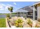 Outdoor patio with a screened-in lanai, lush landscaping, and picturesque water views at 610 Mura Ct, New Smyrna Beach, FL 32168