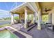 Inviting covered patio featuring a fireplace, ceiling fans, and a refreshing pool with lake views at 610 Mura Ct, New Smyrna Beach, FL 32168