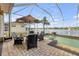 Screened patio features outdoor dining, and lush landscaping, offering an inviting space for relaxation and entertaining at 610 Mura Ct, New Smyrna Beach, FL 32168