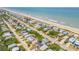 An aerial view of beachfront homes along a serene stretch of sandy beach at 6361 Turtlemound Rd, New Smyrna Beach, FL 32169