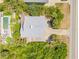 This aerial view showcases a home with a pool, an expansive driveway and lush surroundings at 6361 Turtlemound Rd, New Smyrna Beach, FL 32169