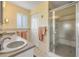 Bathroom featuring double sinks with vanity, a framed mirror, and a shower with glass doors at 6361 Turtlemound Rd, New Smyrna Beach, FL 32169