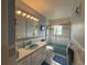 Full bath with a tiled shower/tub, single vanity and a large mirror with Hollywood-style lighting at 6361 Turtlemound Rd, New Smyrna Beach, FL 32169