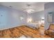 A cozy bedroom with hardwood floors, a ceiling fan, and a comfortable bed with floral bedding at 6361 Turtlemound Rd, New Smyrna Beach, FL 32169