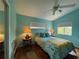 Bright bedroom with a tropical-themed bed, two windows, a ceiling fan and hardwood floors at 6361 Turtlemound Rd, New Smyrna Beach, FL 32169