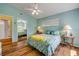 Bright bedroom with wood floors, a ceiling fan, and sliding closet doors at 6361 Turtlemound Rd, New Smyrna Beach, FL 32169