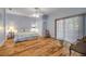 A bright bedroom featuring wood floors, a ceiling fan, a closet, and a sliding glass door at 6361 Turtlemound Rd, New Smyrna Beach, FL 32169