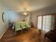 Bedroom featuring hard wood floors, a ceiling fan, a sliding glass door and 3 chairs at 6361 Turtlemound Rd, New Smyrna Beach, FL 32169