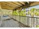 Spacious covered deck features weathered wood, comfortable seating, and lush tropical views at 6361 Turtlemound Rd, New Smyrna Beach, FL 32169