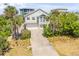Coastal home with a two-car garage and tropical landscaping, offering a blend of comfort and convenience at 6361 Turtlemound Rd, New Smyrna Beach, FL 32169