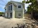 Two-story home featuring a driveway and a mix of lush greenery and mature trees at 6361 Turtlemound Rd, New Smyrna Beach, FL 32169