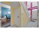 Bright foyer features tile flooring and a staircase leading to the second floor, with colorful living room visible through the doorway at 6361 Turtlemound Rd, New Smyrna Beach, FL 32169