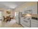 Cozy kitchen includes white appliances, a dining table set, and a sliding door to the outside at 6361 Turtlemound Rd, New Smyrna Beach, FL 32169
