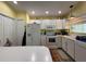 Bright kitchen with white appliances and ample storage space in the white cabinets, microwave, stove, and refrigerator at 6361 Turtlemound Rd, New Smyrna Beach, FL 32169