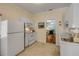 Bright kitchen features white appliances, tile floor, and an open doorway leading to the living area at 6361 Turtlemound Rd, New Smyrna Beach, FL 32169