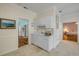 Bright kitchen with white cabinets, an adjacent dining area, and hardwood floors in the next room at 6361 Turtlemound Rd, New Smyrna Beach, FL 32169