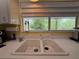 Close up of a kitchen sink with a window that offers outdoor views providing natural light to the workspace at 6361 Turtlemound Rd, New Smyrna Beach, FL 32169