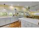 Spacious kitchen featuring white cabinets, an island with breakfast bar, and seamless connection to the dining and living area at 6361 Turtlemound Rd, New Smyrna Beach, FL 32169