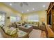 Bright living room with wicker furniture, tropical decor and sunny windows at 6361 Turtlemound Rd, New Smyrna Beach, FL 32169