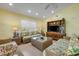 Inviting living room with a large entertainment center, wicker furniture and ample natural light at 6361 Turtlemound Rd, New Smyrna Beach, FL 32169