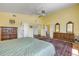 Large primary bedroom with hardwood floors, two dressers, ceiling fan, a patterned area rug and full bathrooms at 6361 Turtlemound Rd, New Smyrna Beach, FL 32169