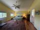 Large primary bedroom with two windows, a ceiling fan, hardwood floors and an adjacent full bathroom at 6361 Turtlemound Rd, New Smyrna Beach, FL 32169