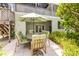 Cozy patio area with an outdoor dining set and lush landscaping, perfect for entertaining at 6361 Turtlemound Rd, New Smyrna Beach, FL 32169