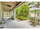 Charming tiled patio with outdoor dining area and lush green landscaping at 6361 Turtlemound Rd, New Smyrna Beach, FL 32169