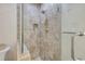 Modern tiled shower featuring glass doors, a rainfall showerhead, and a built-in niche for storage at 6361 Turtlemound Rd, New Smyrna Beach, FL 32169