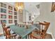 Charming dining room with a blue table, wooden chairs, and an array of colorful framed artwork at 6542 Rover Way, St Cloud, FL 34771