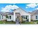 Inviting home exterior with covered porch, stylish landscaping, and a light blue front door under a cloudy sky at 6542 Rover Way, St Cloud, FL 34771